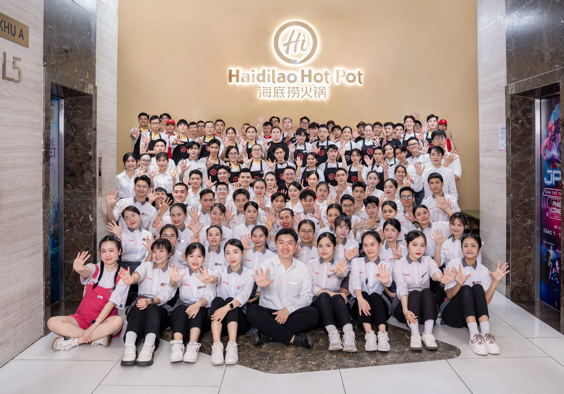 Ảnh tập thể in lớn treo tường cửa hàng Hadilao Gigamal Thủ Đức · décor không gian F&B